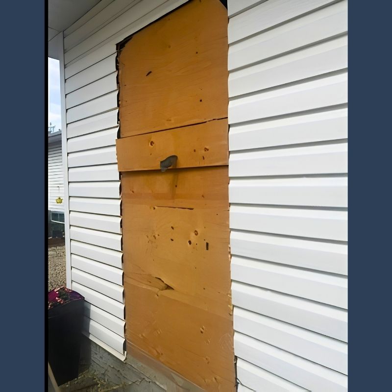 Exterior door opening boarded up with plywood before replacement in Edmonton