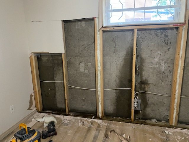 Basement wall opened up to the studs with damaged material removed