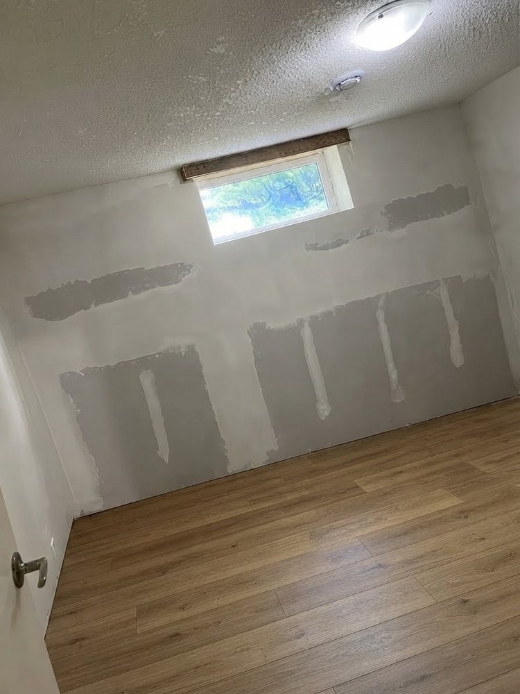 Basement wall with new drywall hung and taped, with joint compound applied